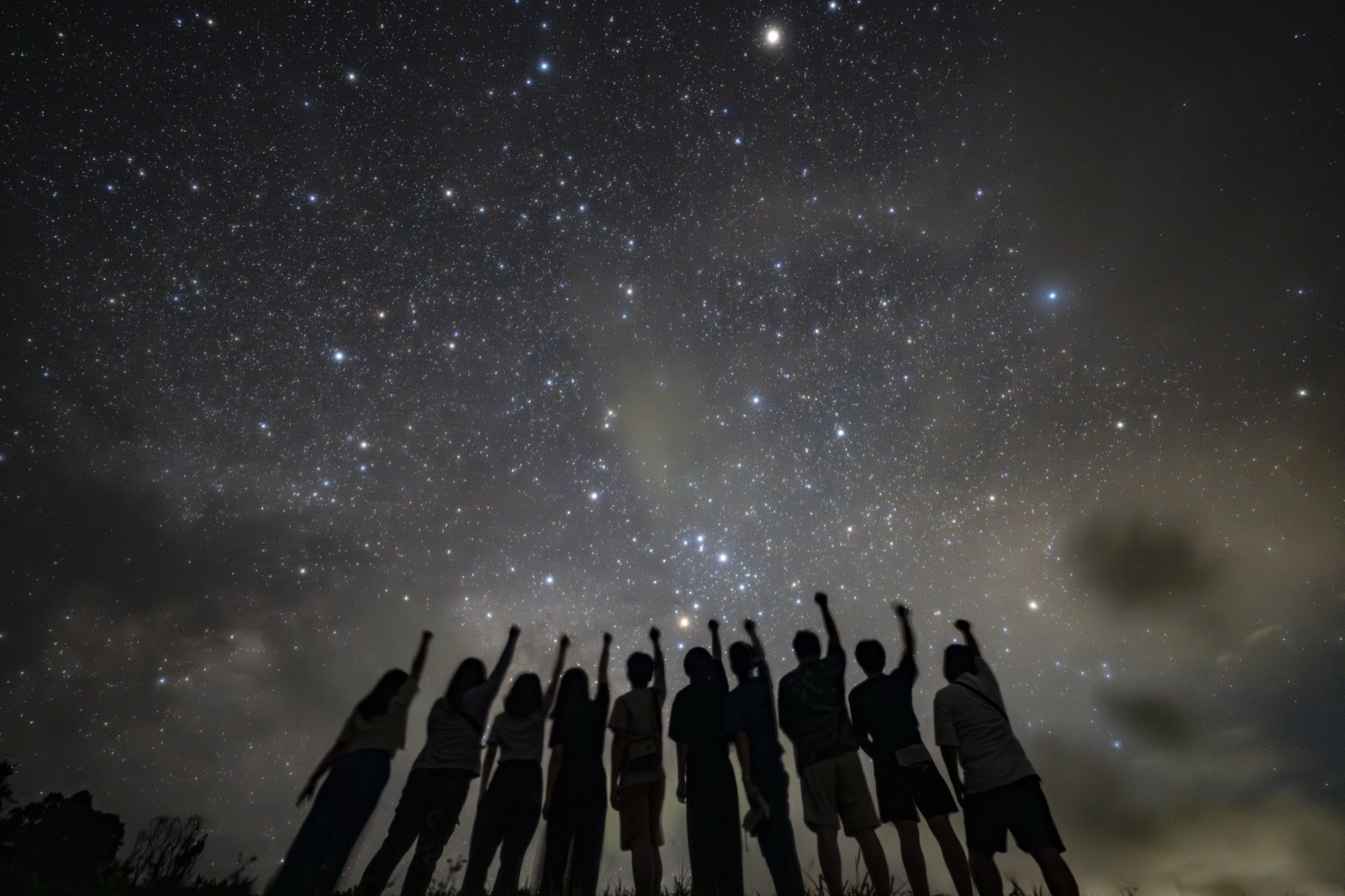 宮古島の星空ツアーで、大人数のグループが星空を見上げる様子